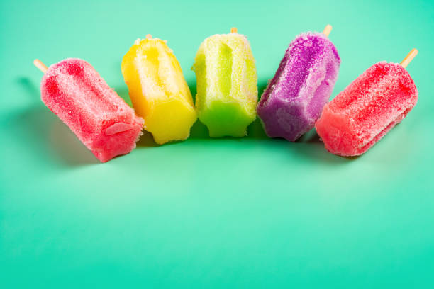 istock side view multi-color popsicles line up on green background with copy space 1132967739