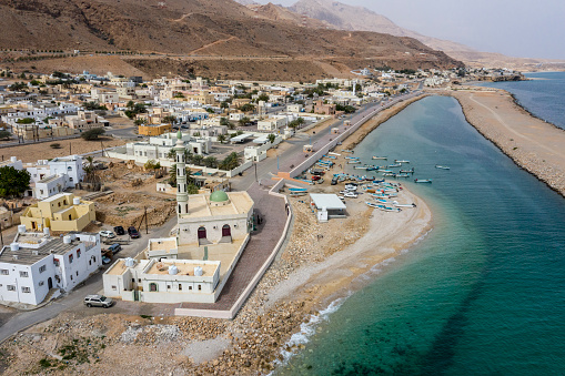 Small town mosque with a single minaret on the shore of a coastal town of Tiwi, Oman.