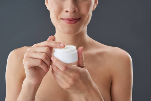istock Gorgeous lady holding white jar with cream in hands 1132969745