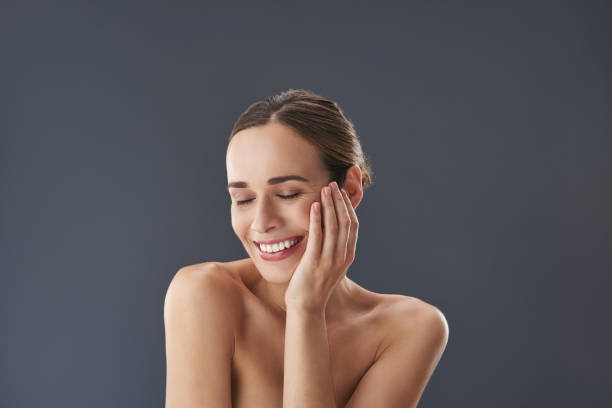 istock Gorgeous lady closing eyes and touching her cheek by hand 1132969772