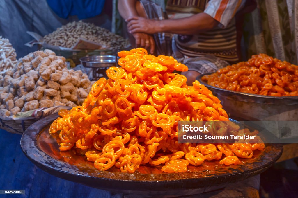 Freshly cooked traditional Indian dessert or sweets Jalebi is selling at local market. Freshly cooked deep fried traditional Indian dessert or sweets Jalebi is selling at local market. Asia Stock Photo