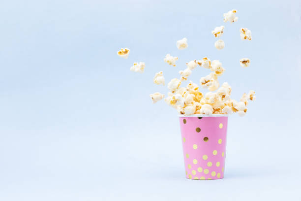 istock Flying Popcorn in a bright glass and on a blue background. 1132972468