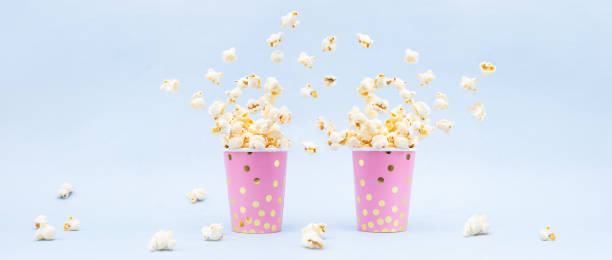 istock Flying Popcorn in a bright glass and on a blue background. Copy space 1132972472