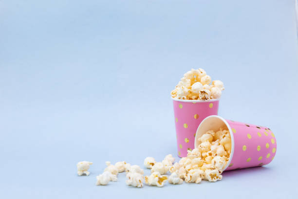 istock Two cups of tasty popcorn on a blue background 1132972474