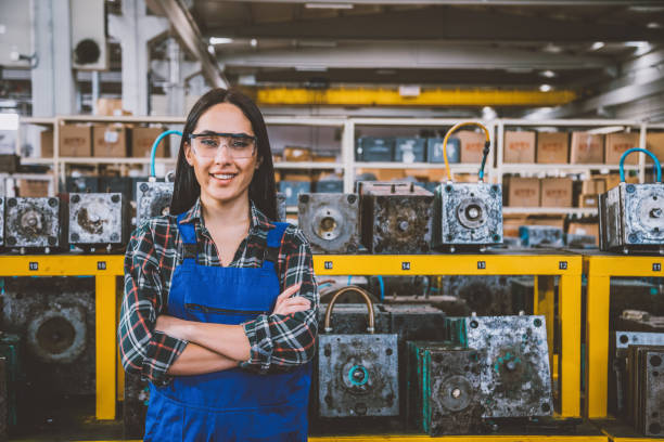 портрет улыбающейся молодой женщины-техника на фабрике - manufacturing occupation manual worker factory cheerful стоковые фото и изображения
