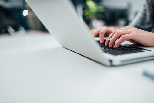 Female person typing on laptop. Close-up, copy space.