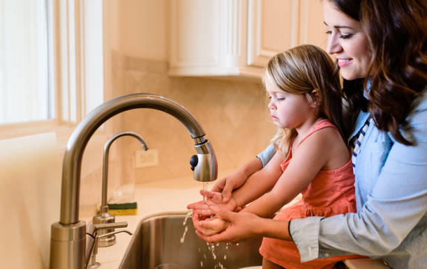 istock Mother and Daughter Washing Hands 1132973845