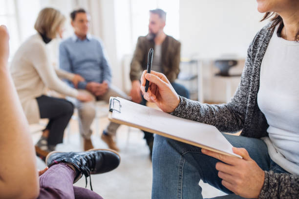 istock A midsection of counsellor with clipboard talking to a client during group therapy. 1132974323