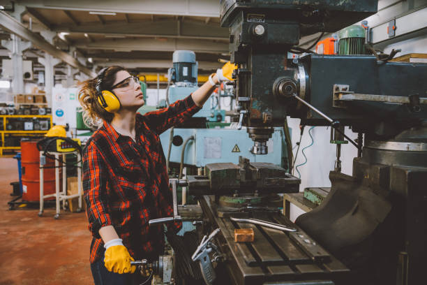 istock Young female lathe worker working with milling machine in factory 1132974329