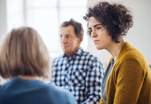 istock Men and women sitting in a circle during group therapy, talking. 1132974971