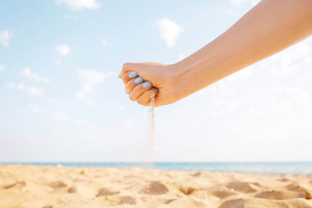 istock Woman’s hand pours sand outdoor. 1132977318