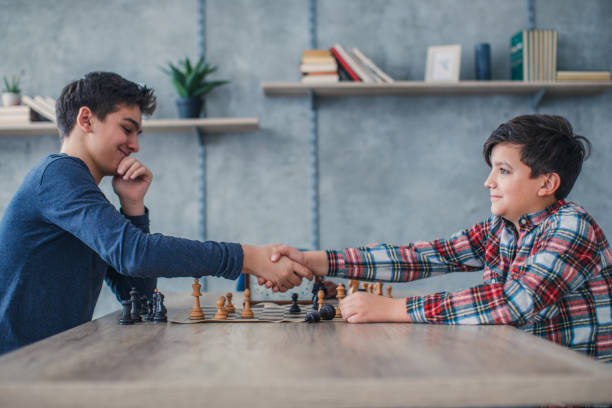istock Two boys handshake after a game of chess 1132978654
