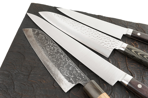 Four different kitchen knives on black cutting board