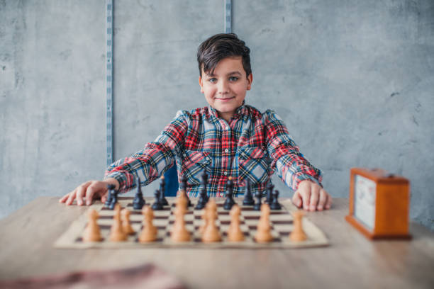 istock Young boy sitting in front of chess board 1132978883