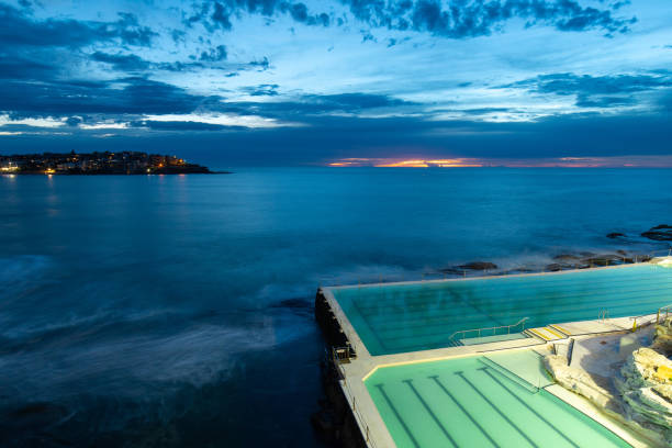 Bondi Icebergs Dawn Sydney, Australia - February 9, 2019: Dawn view of Bondi Icebergs pool with light on. bondi beach sunrise stock pictures, royalty-free photos & images