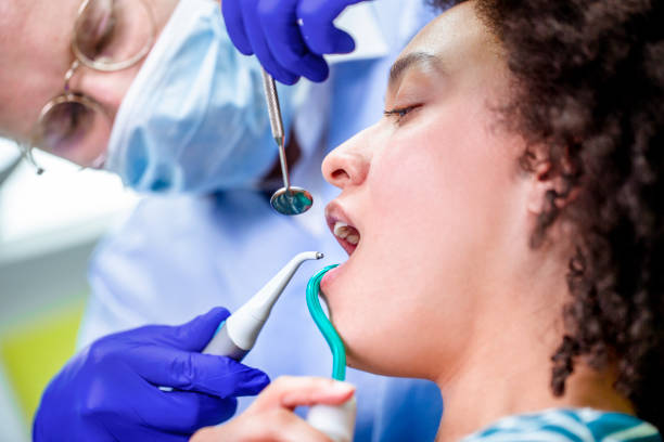 istock A dental checkup. Dentist using a mouth mirror, irrigation syringe and a saliva ejector 1132980771