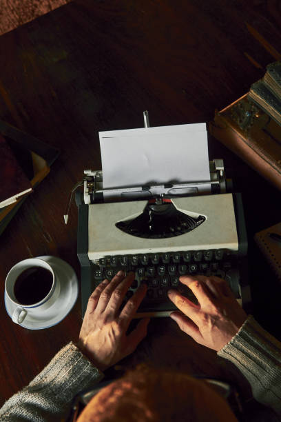 giovane che scrive su una vecchia macchina da scrivere. - machine typewriter human hand typing foto e immagini stock