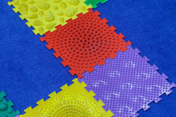 istock Children's large mosaic multi colored constructor on a blue carpet background. Baby mat massager 1132982607