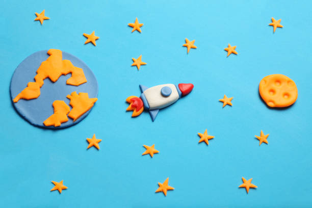 istock Creative craft plasticine rocket in open space, astronaut dreams. Stars, planet earth and moon. Cartoon art 1132983023