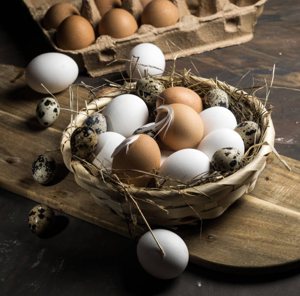 istock Chicken and quail eggs on wooden background 1132983262
