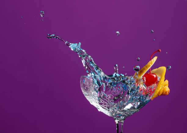 istock Cocktail in glass with splashes garnished with lemon and cherries. 1132984303