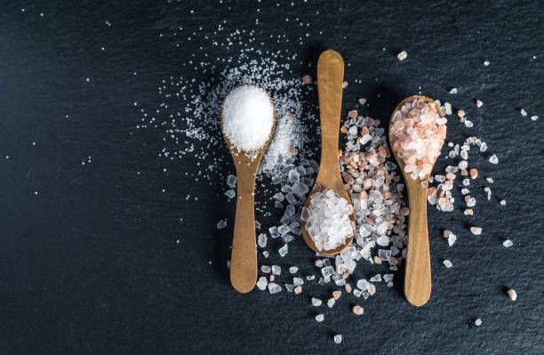 diversi tipi di sale. vista dall'alto su tre cucchiai di legno - sale da cucina foto e immagini stock