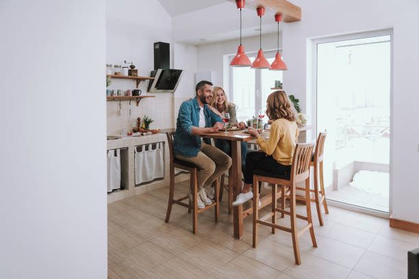 istock Happy family chatting and laughing while having dinner at home 1132987273