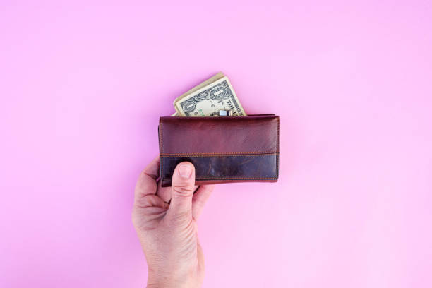 istock hand holds wallet with United States dollar 1132987727