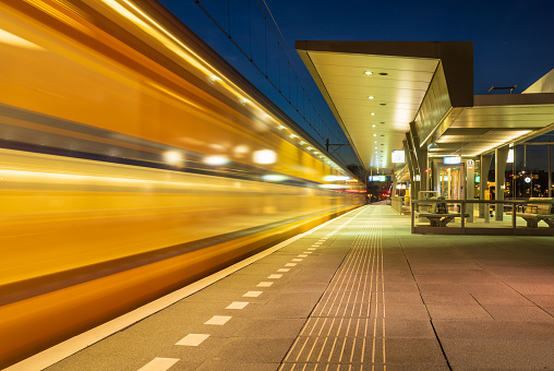Train leaving the platform on a train station in the evening. Groningen, Holland.