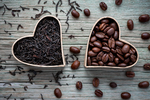 Coffee beans and black tea on a wooden background. Love coffee and tea.