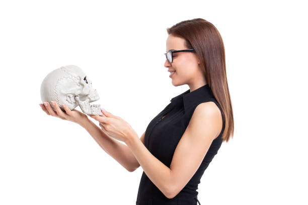istock Young businesswoman talking with skull, profile view isolated 1132989408