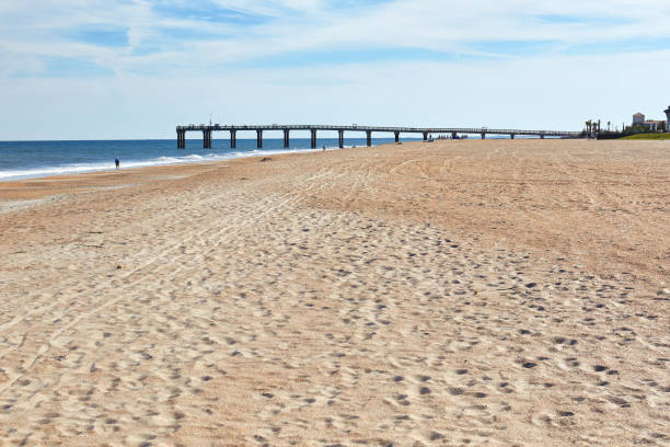 Fishing pier, sand and ocean waves at St. Augustine Beach, Florida