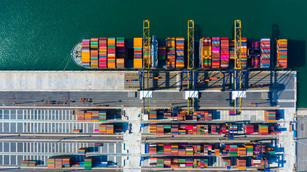 istock Container cargo freight ship with working crane bridge discharge at container terminal, Aerial top view container ship at deep sea port. 1132990134