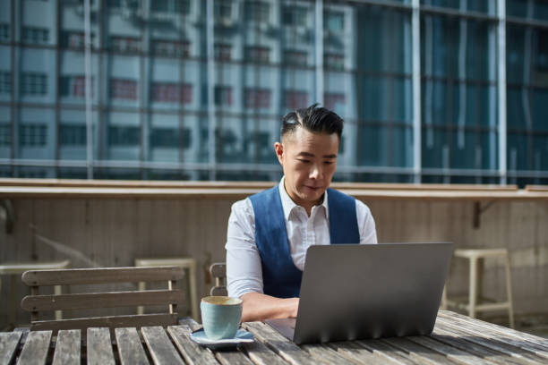istock Businessman using laptop at table in cafeteria 1132990967