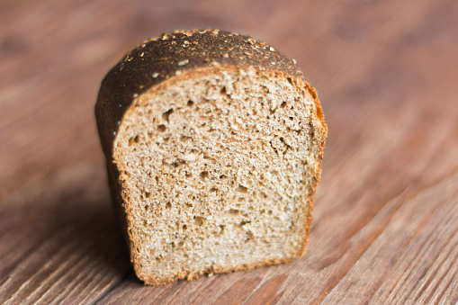 rye grey bread with spices on wooden background