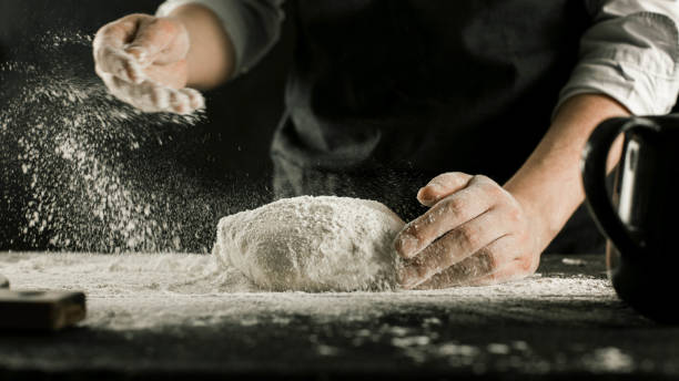 istock Male chef hands knead dough with flour on kitchen table 1132994985