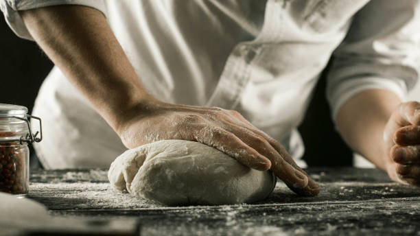 istock Male chef hands knead dough with flour on kitchen table 1132995026