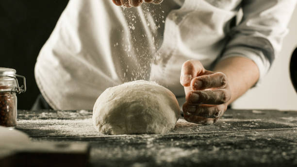 istock Male chef hands knead dough with flour on kitchen table 1132995045
