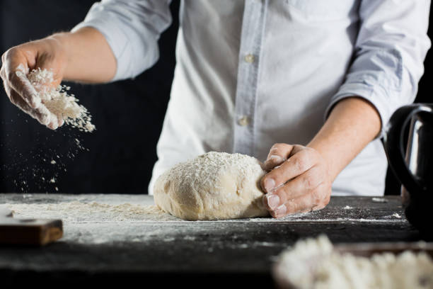 istock Cook sprinkles dough with flour on the kitchen table 1132995060