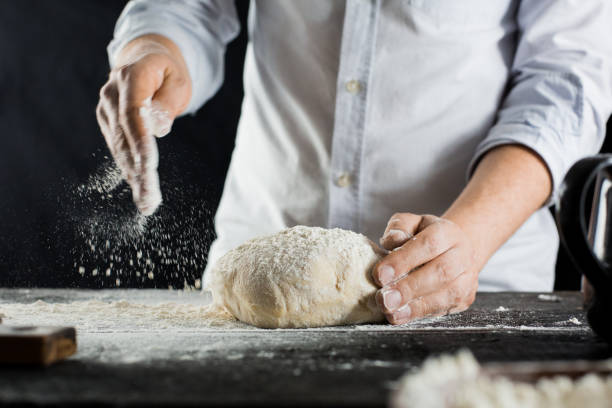 istock Cook sprinkles dough with flour on the kitchen table 1132995067
