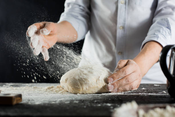 istock Cook sprinkles dough with flour on the kitchen table 1132995071