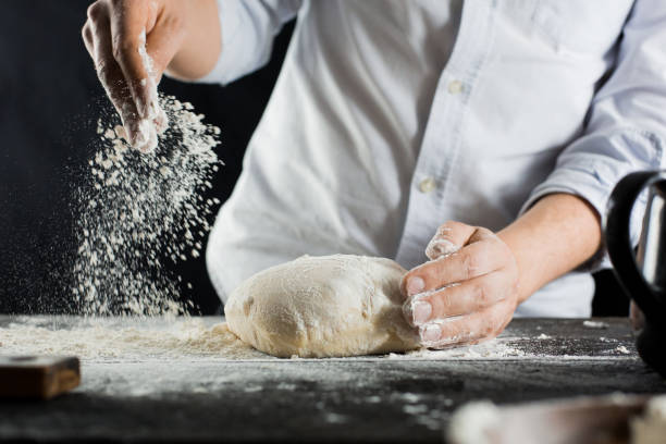 istock Cook sprinkles dough with flour on the kitchen table 1132995076