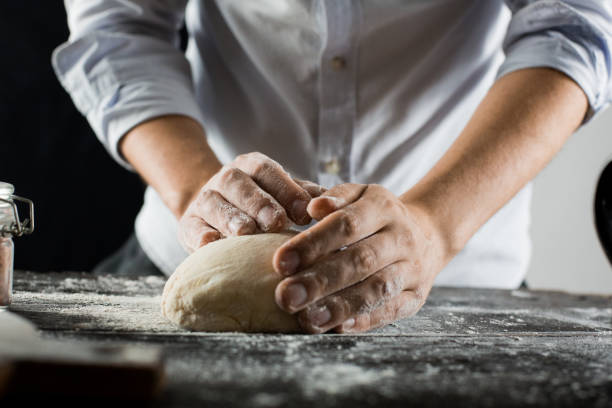 istock Cook kneads dough with flour on kitchen table 1132995080