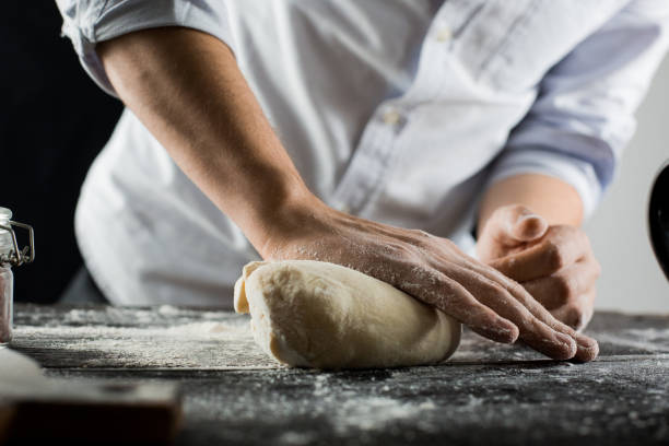 istock Cook kneads dough with flour on kitchen table 1132995091
