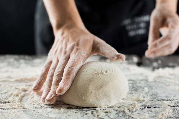 Male chef hands knead dough with flour on kitchen table Male chef hands knead dough with flour on kitchen table side view standing desk photos stock pictures, royalty-free photos & images
