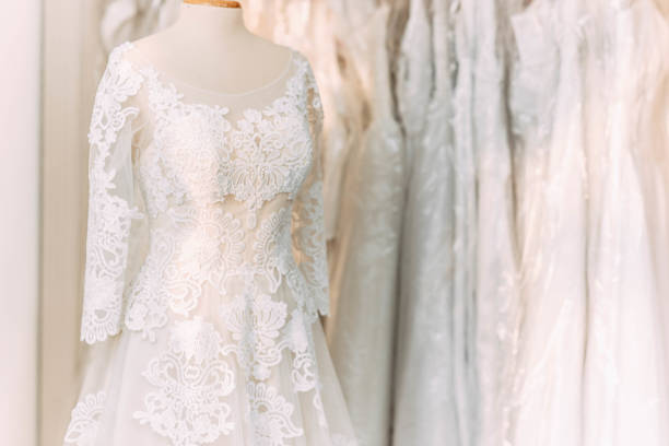lace wedding dress on a mannequin in a wedding clothing store. lace wedding dress on a mannequin in a wedding clothing store. bridal shop photos stock pictures, royalty-free photos & images