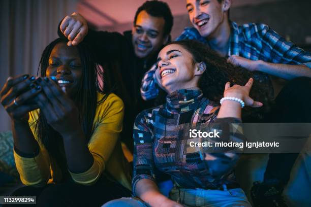 Group Of Friends Watching Funny Videos On Mobile Phone Stock Photo -  Download Image Now - iStock