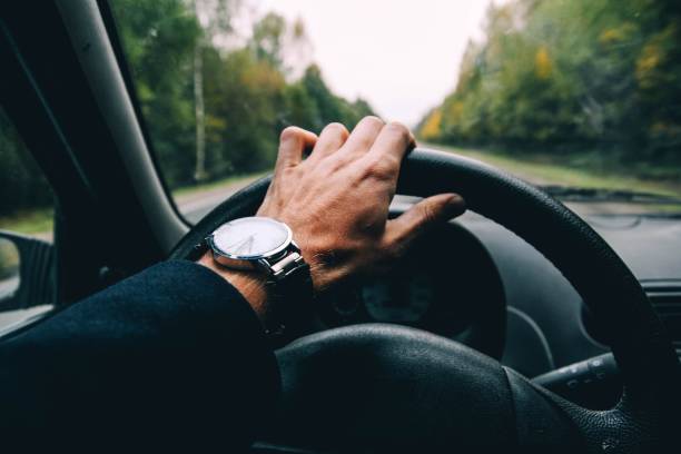 istock car driver holds the wheel on a sunny day. 1132999408