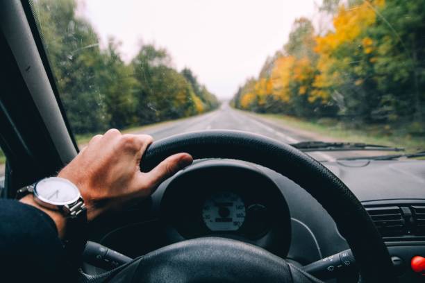 車の運転手は晴れた日に車輪を保持します。 - car driving inside of indoors ストックフォトと画像