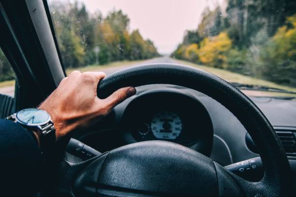 istock car driver holds the wheel on a sunny day. 1132999521